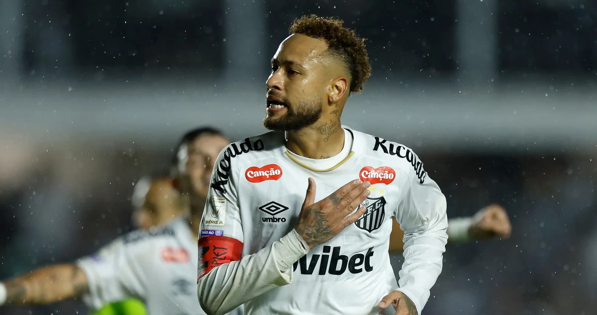 Jugador celebrando con la camiseta de Santos en lluvia