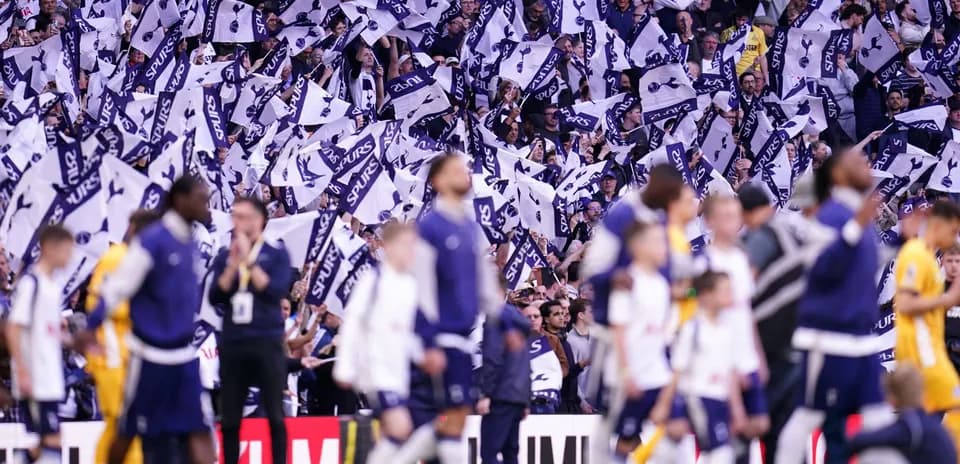 Aficionados de Spurs agitando banderas en el estadio