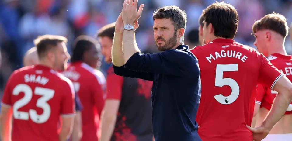 Entrenador aplaudiendo junto a jugadores de Manchester United