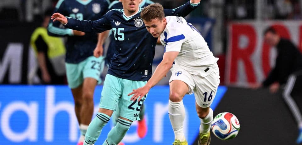 Jugador de Finlandia despojando balón a alemán