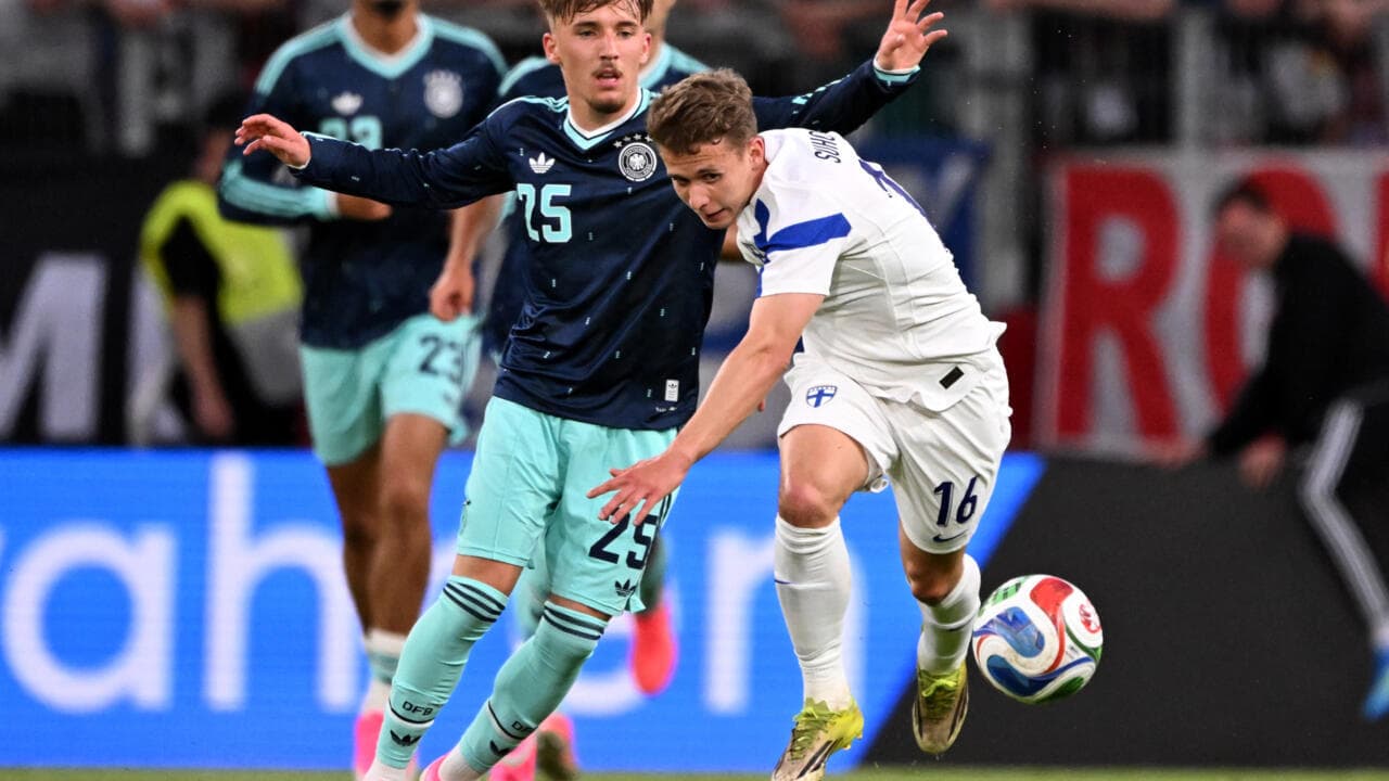 Jugador de Finlandia despojando balón a alemán