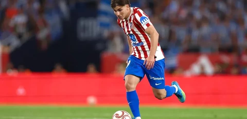Jugador de Atlético de Madrid driblando el balón en campo