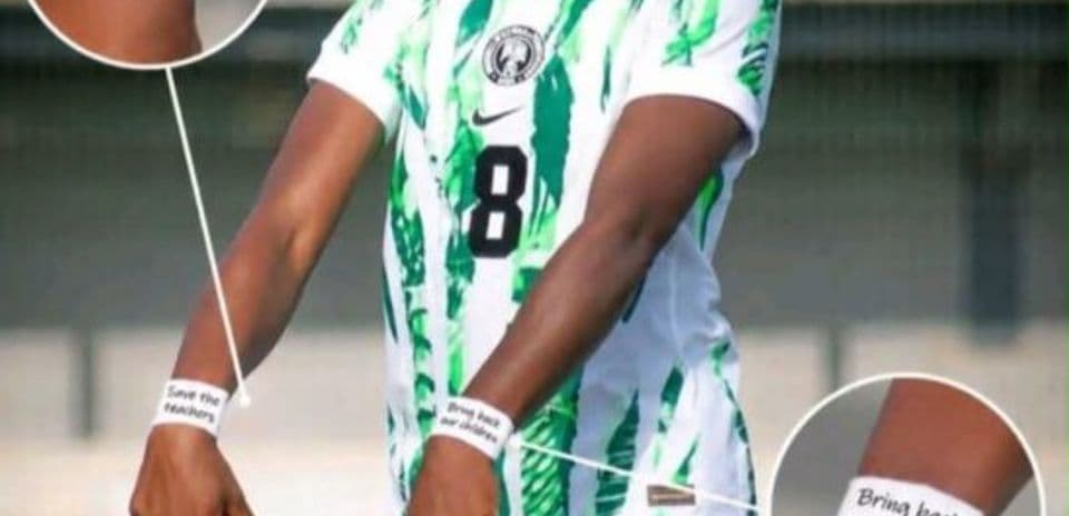 Jugadora con camiseta de Nigeria mostrando mensajes en muñecas
