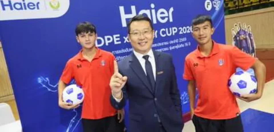 Tres personas posando con balones de fútbol