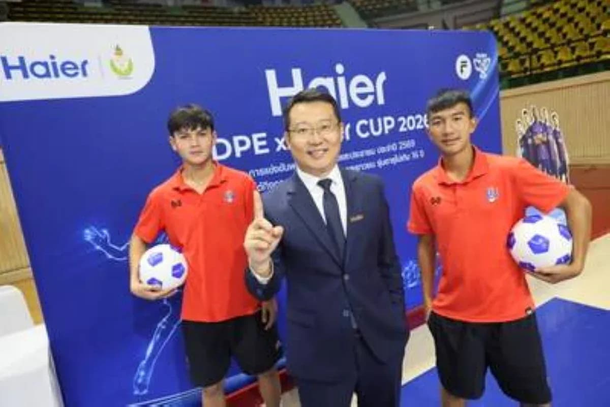 Tres personas posando con balones de fútbol