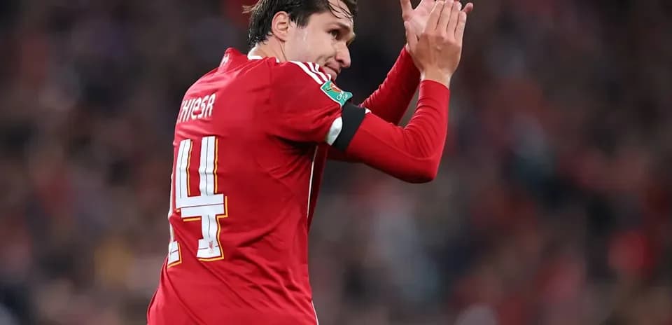 Jugador aplaudiendo durante el partido con uniforme rojo