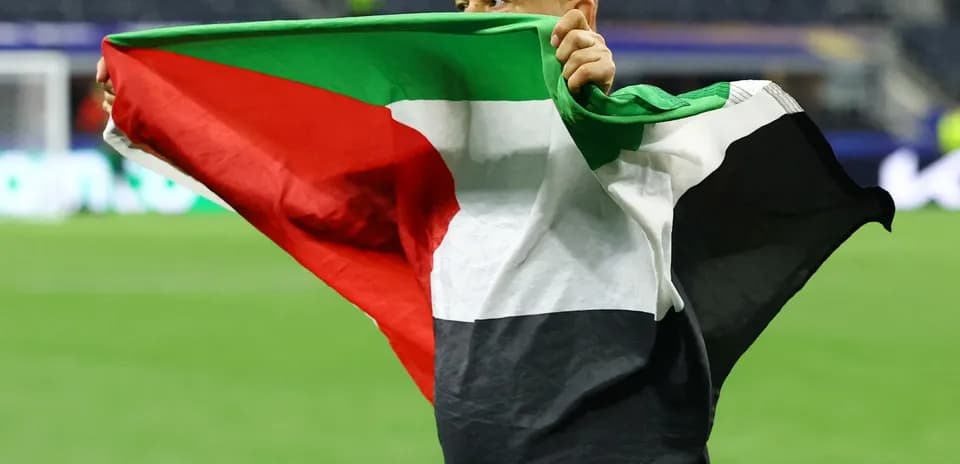 Persona sosteniendo una bandera en el campo de juego