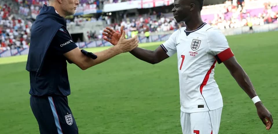 Entrenador y jugador de Inglaterra chocando manos en el campo