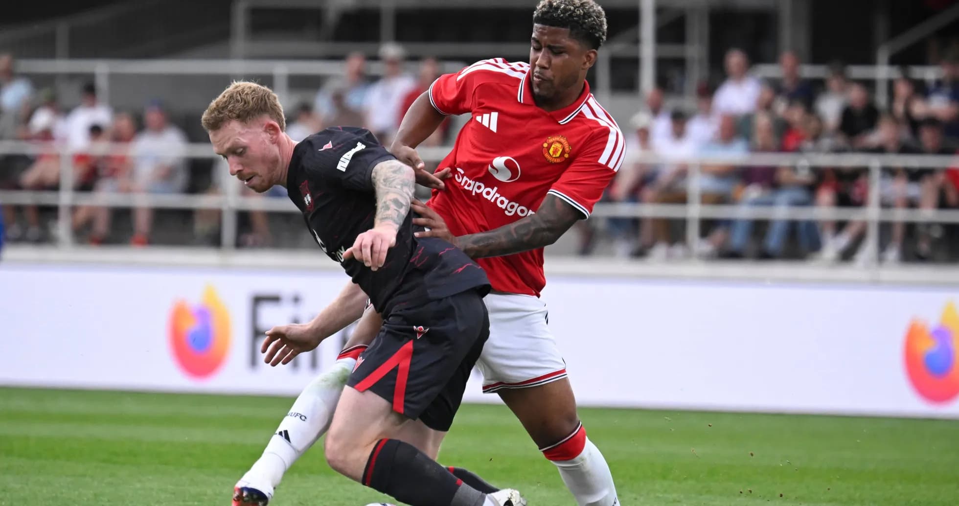 Jugador de Manchester United presionando a oponente en campo
