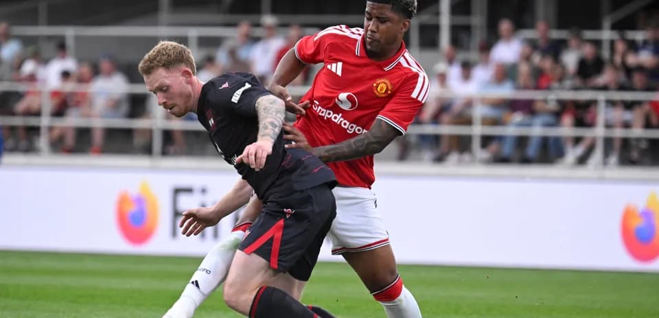 Jugador de Manchester United presionando a oponente en campo