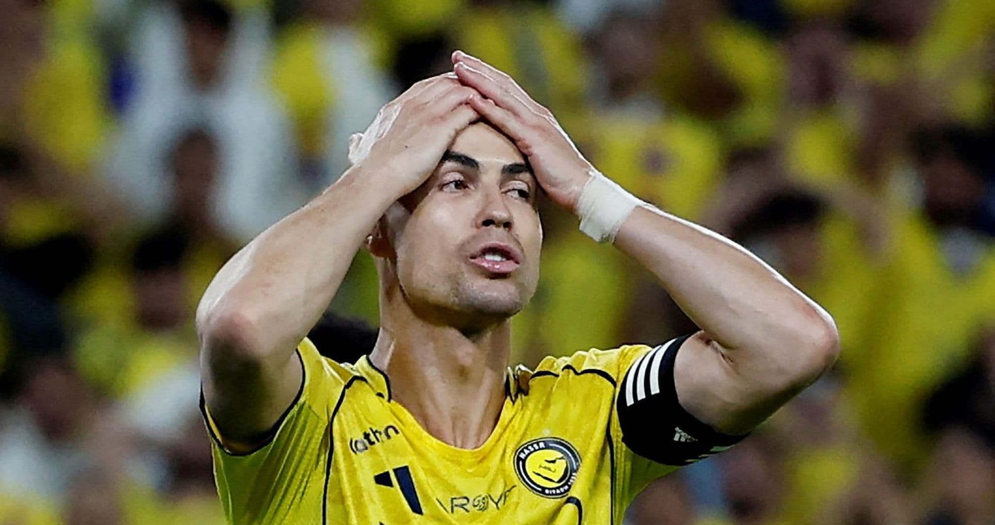 Jugador con camiseta amarilla sosteniendo su cabeza