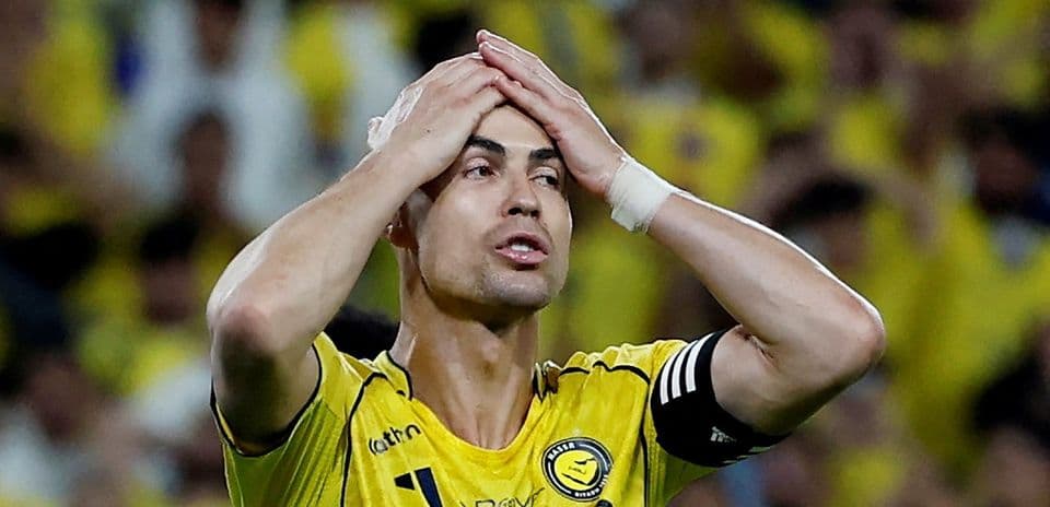 Jugador con camiseta amarilla sosteniendo su cabeza