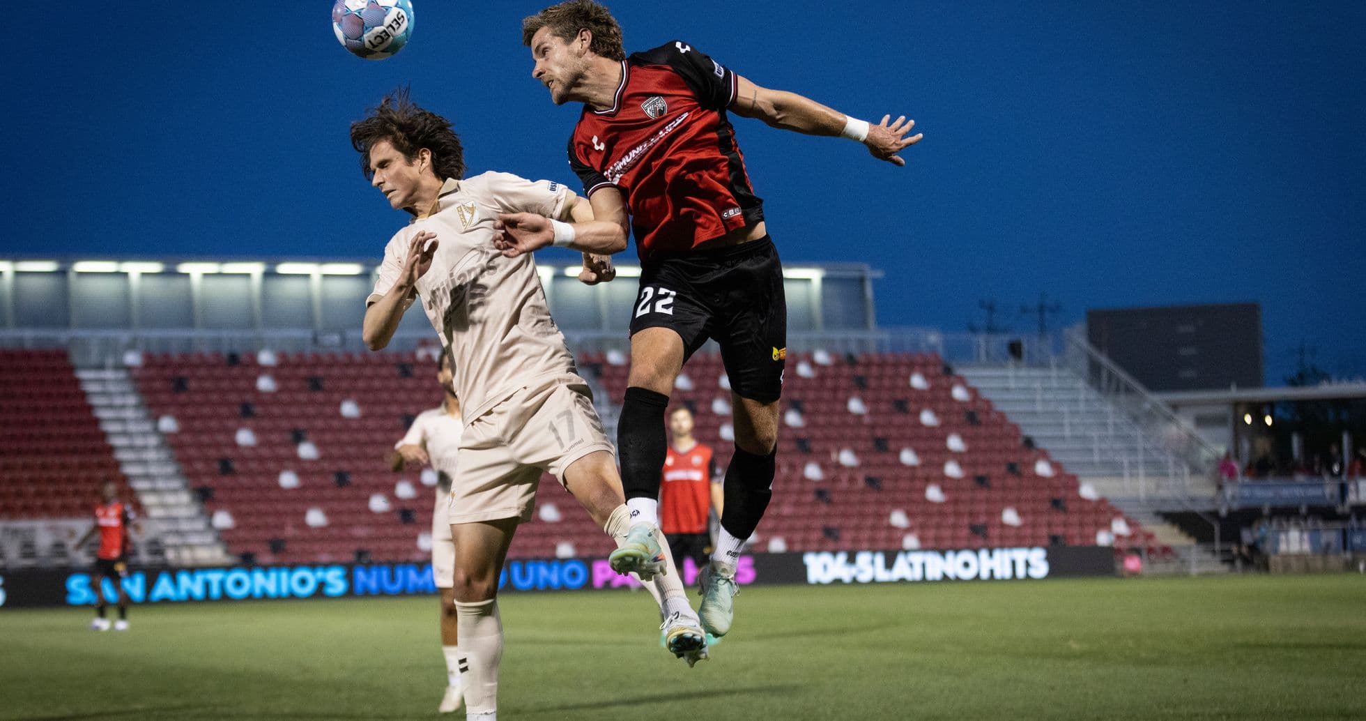 Jugador de FC Tulsa saltando por el balón