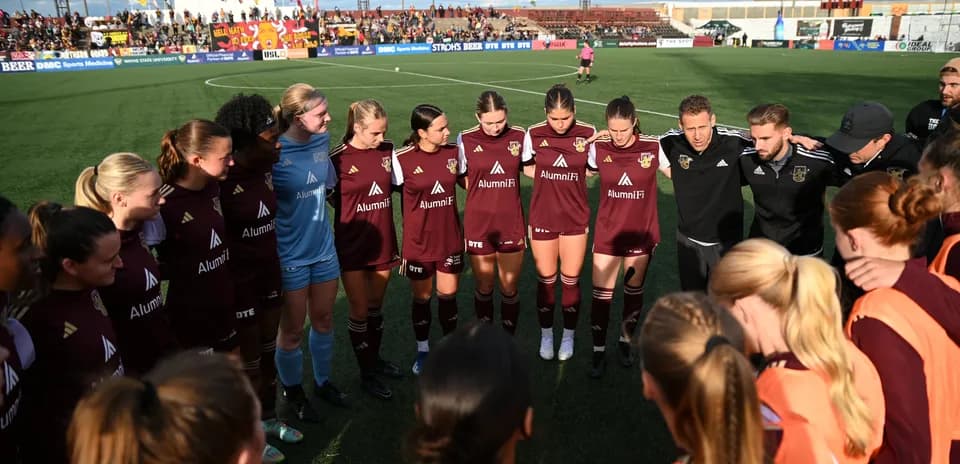 Jugadoras de Detroit City en círculo durante el partido