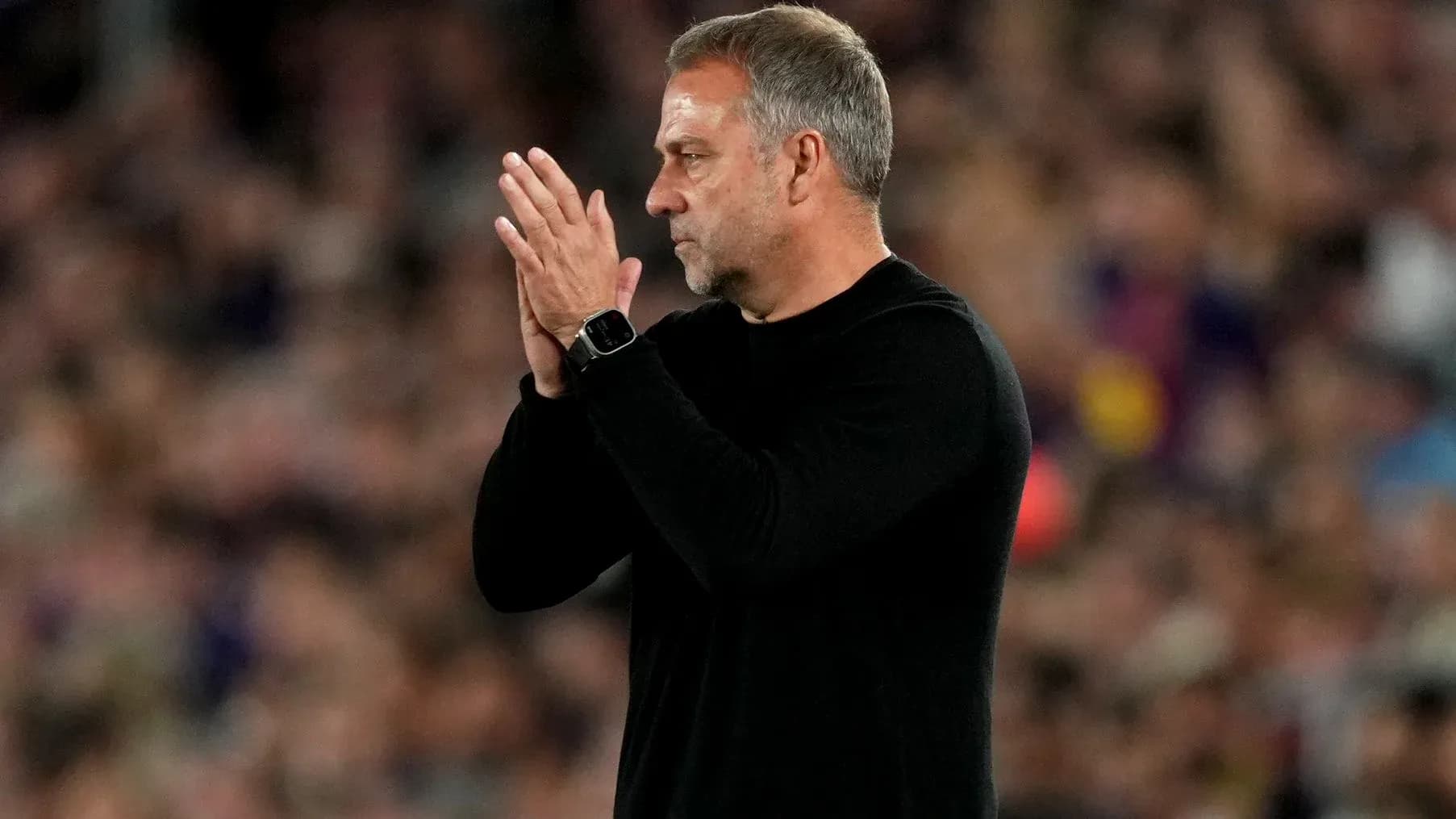 Entrenador aplaudiendo durante un partido de fútbol