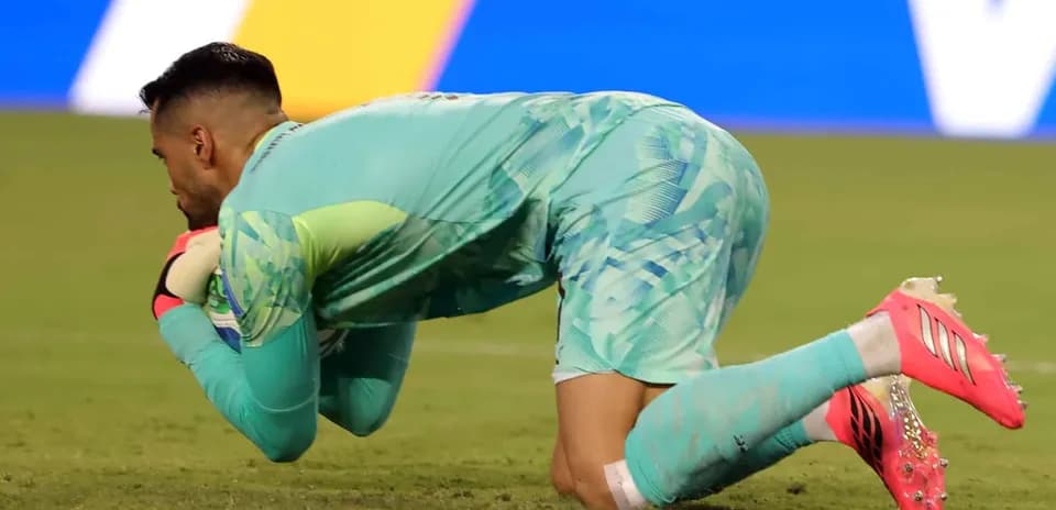 Portero atrapando el balón durante el partido