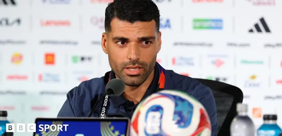 Jugador en conferencia de prensa con balón de fútbol