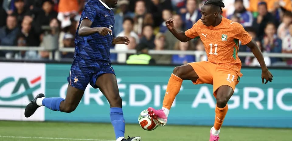 Jugador de Francia y Costa de Marfil compiten por el balón