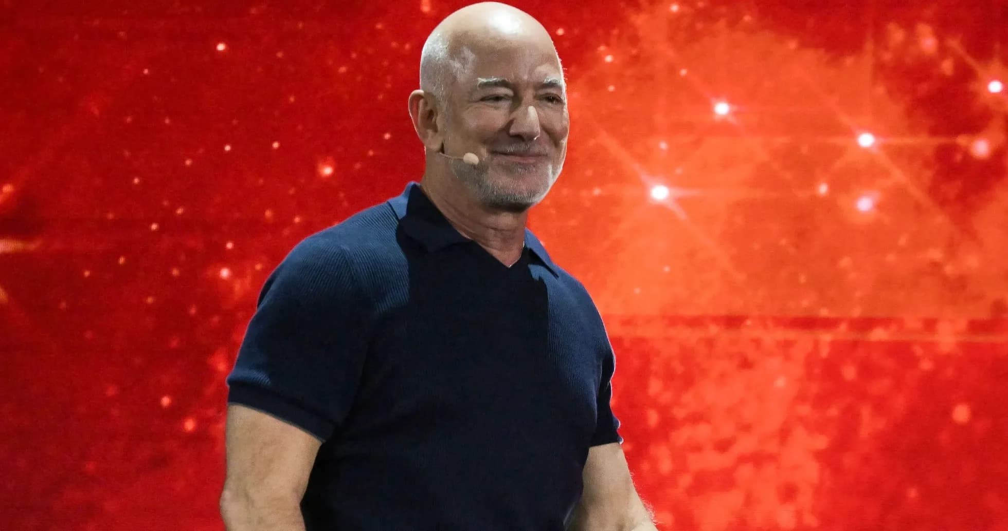 Hombre con micrófono en fondo rojo durante presentación