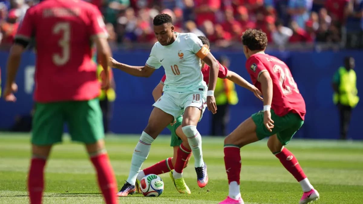 Jugador de Francia driblando entre defensores de Marruecos
