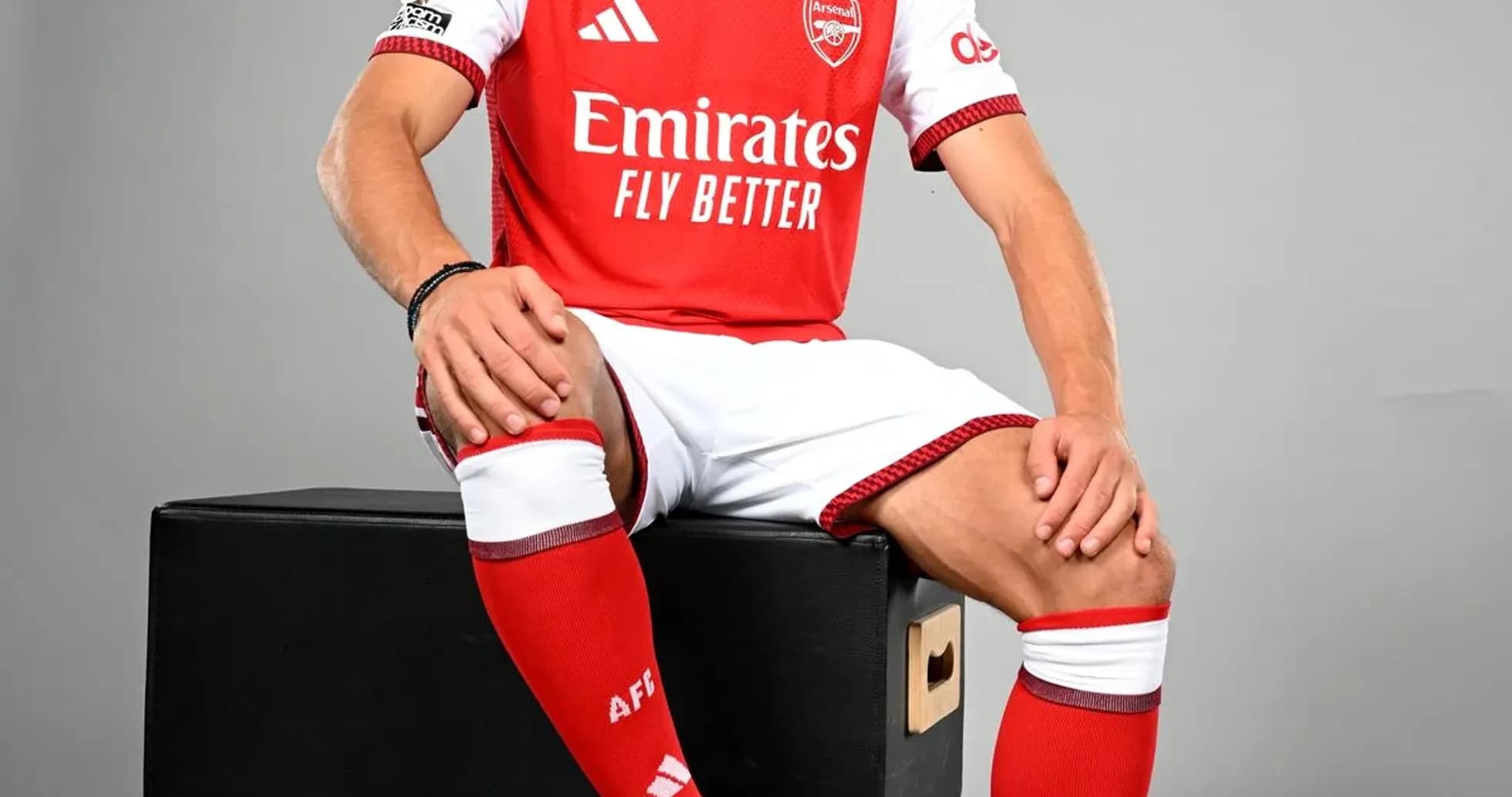 Jugador posando con uniforme de Arsenal y balón
