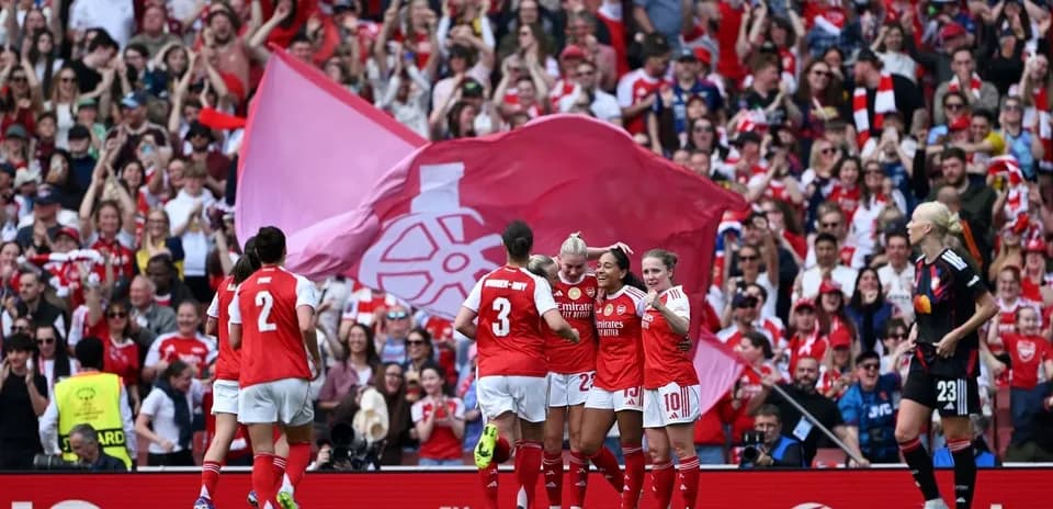 Jugadoras de Arsenal celebrando con aficionados en el estadio