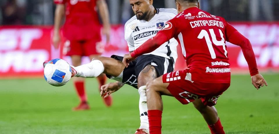 Arturo Vidal y jugador de Nublense en acción