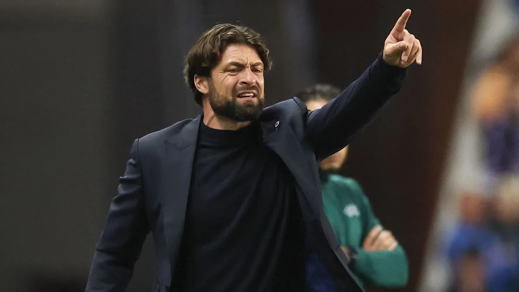 Entrenador dando instrucciones desde la línea de banda