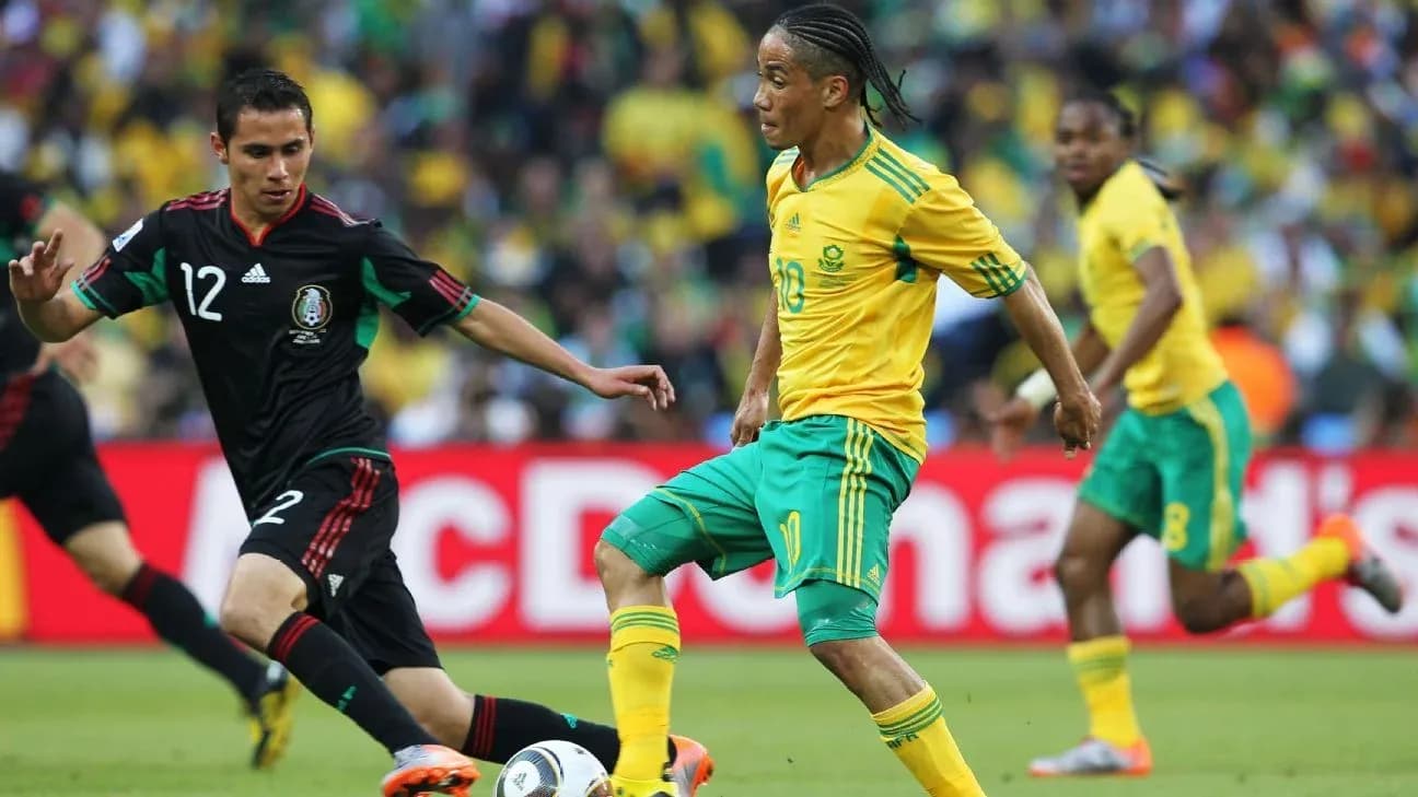 Jugadores de México y Sudáfrica compitiendo por el balón