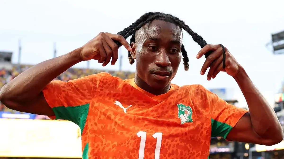 Jugador con camiseta naranja ajustándose el cabello