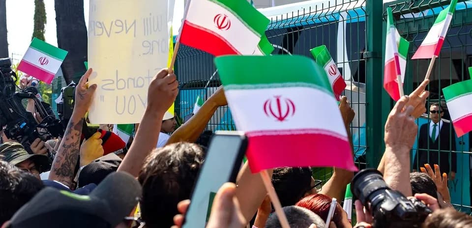 Protesters holding Iranian flags and signs