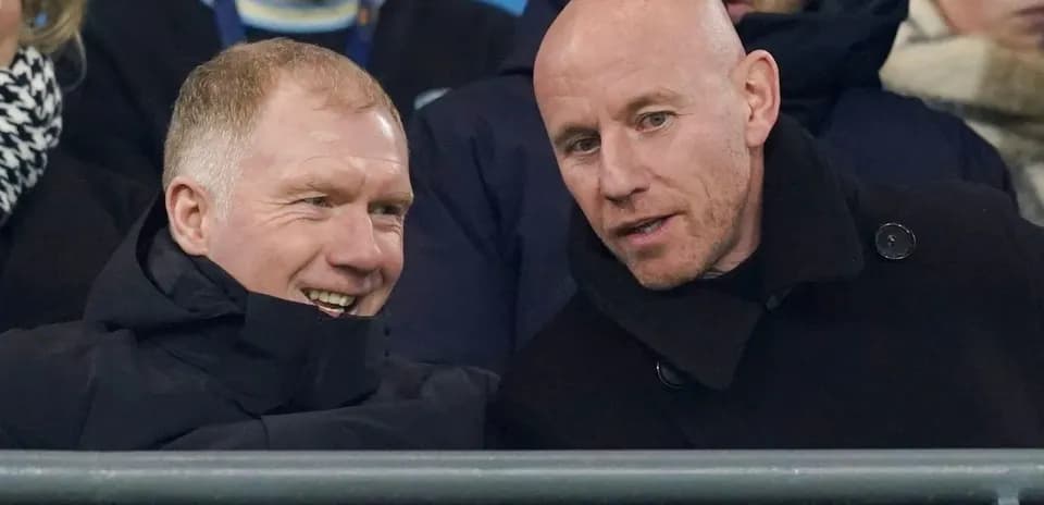 Dos hombres conversando en el estadio durante un partido