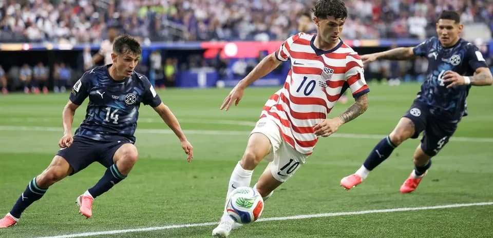 Cristian Pulisic dribbling past defenders during match