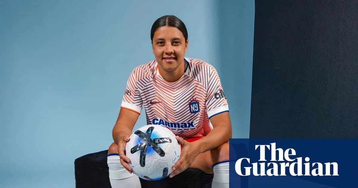 Jugadora de fútbol sosteniendo balón en estudio