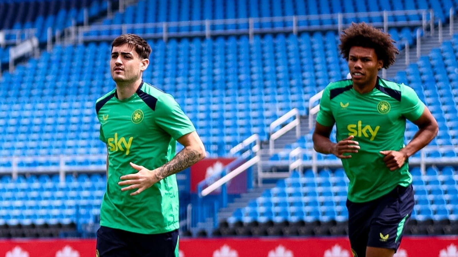 Jugadores entrenando en el estadio con camisetas verdes