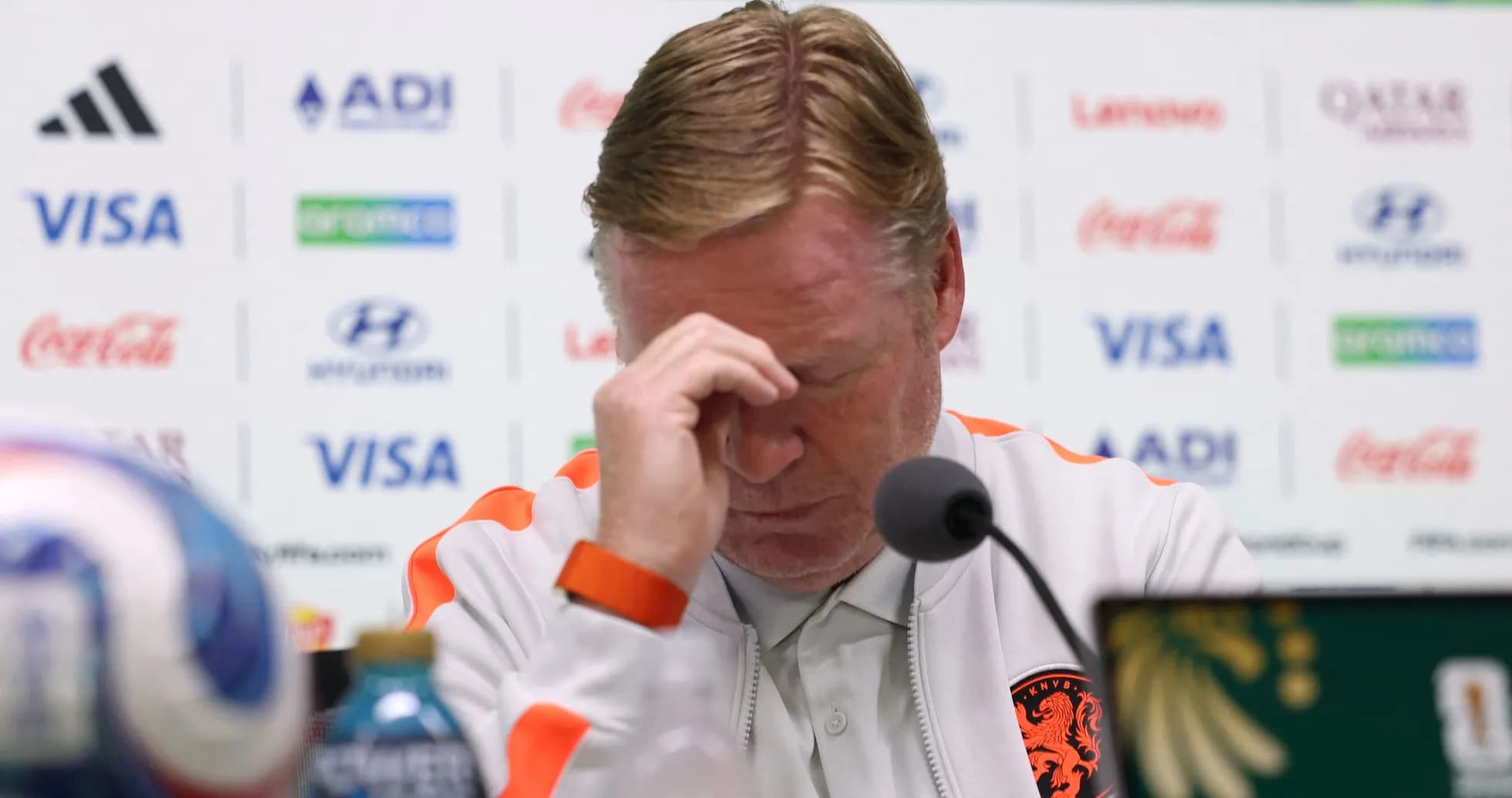 Entrenador en conferencia de prensa con rostro preocupado