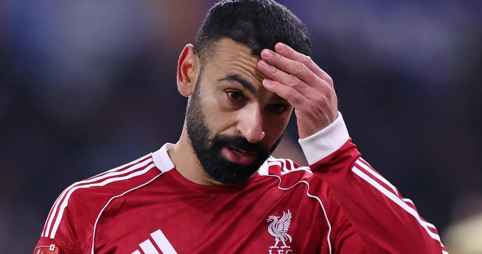 Jugador de Liverpool con camiseta roja, tocándose la frente