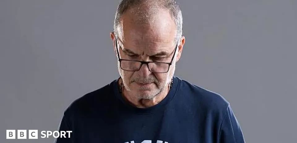 Hombre con gafas mirando hacia abajo en fondo gris