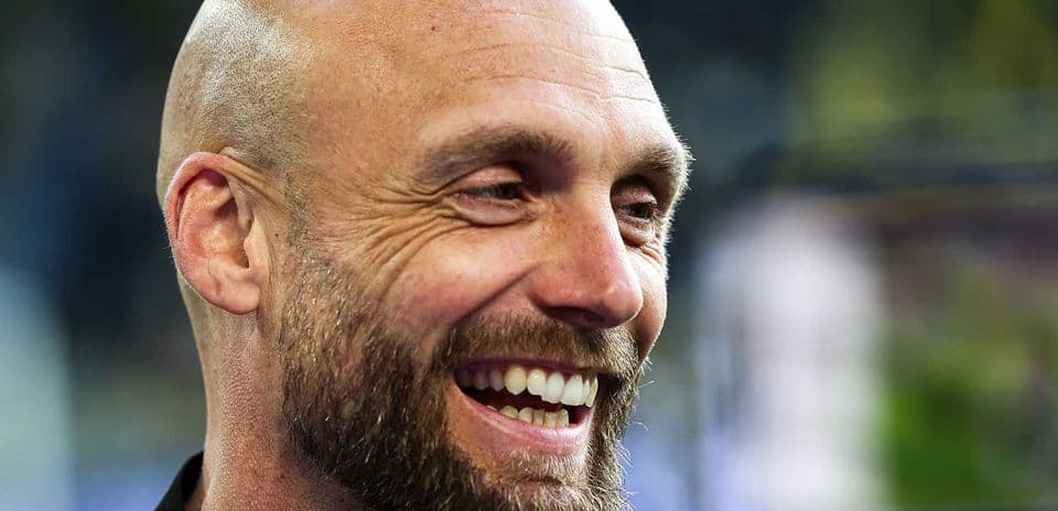 Entrenador sonriendo en una conferencia de prensa
