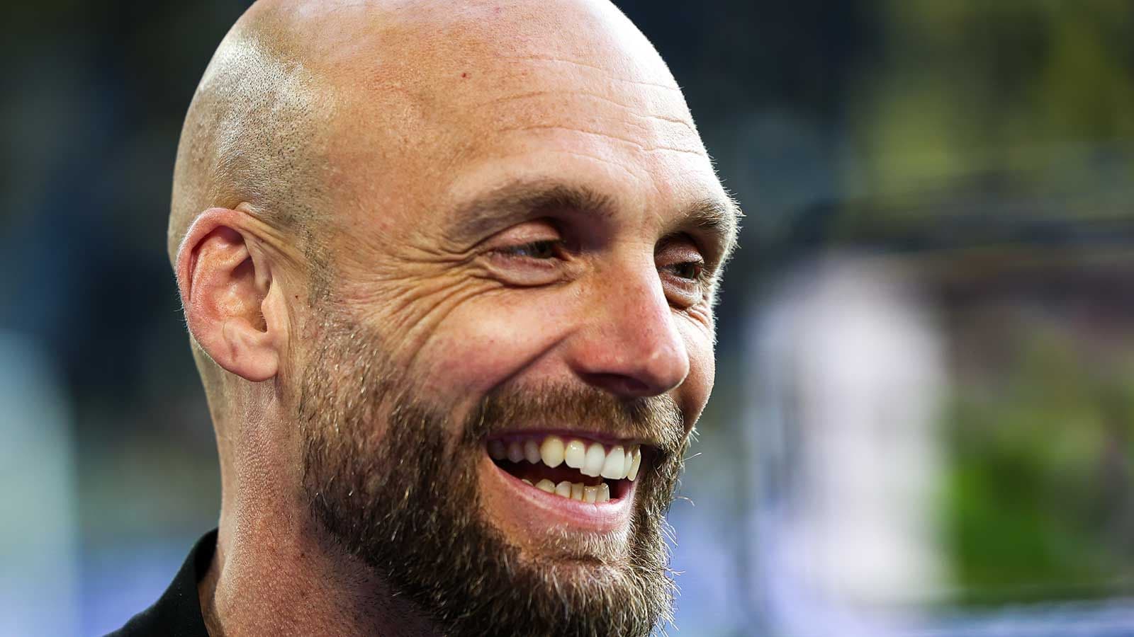 Entrenador sonriendo en una conferencia de prensa