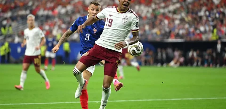 Jugador español driblando a defensor francés en partido