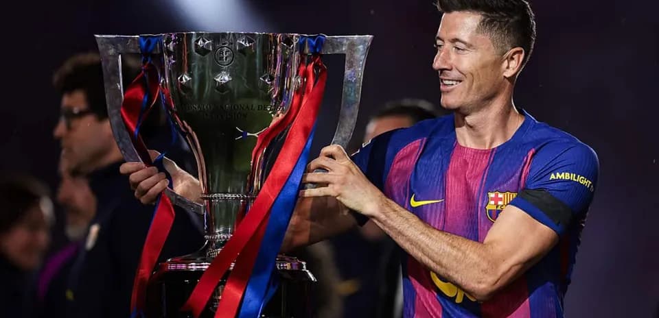 Jugador sosteniendo un trofeo de fútbol en celebración