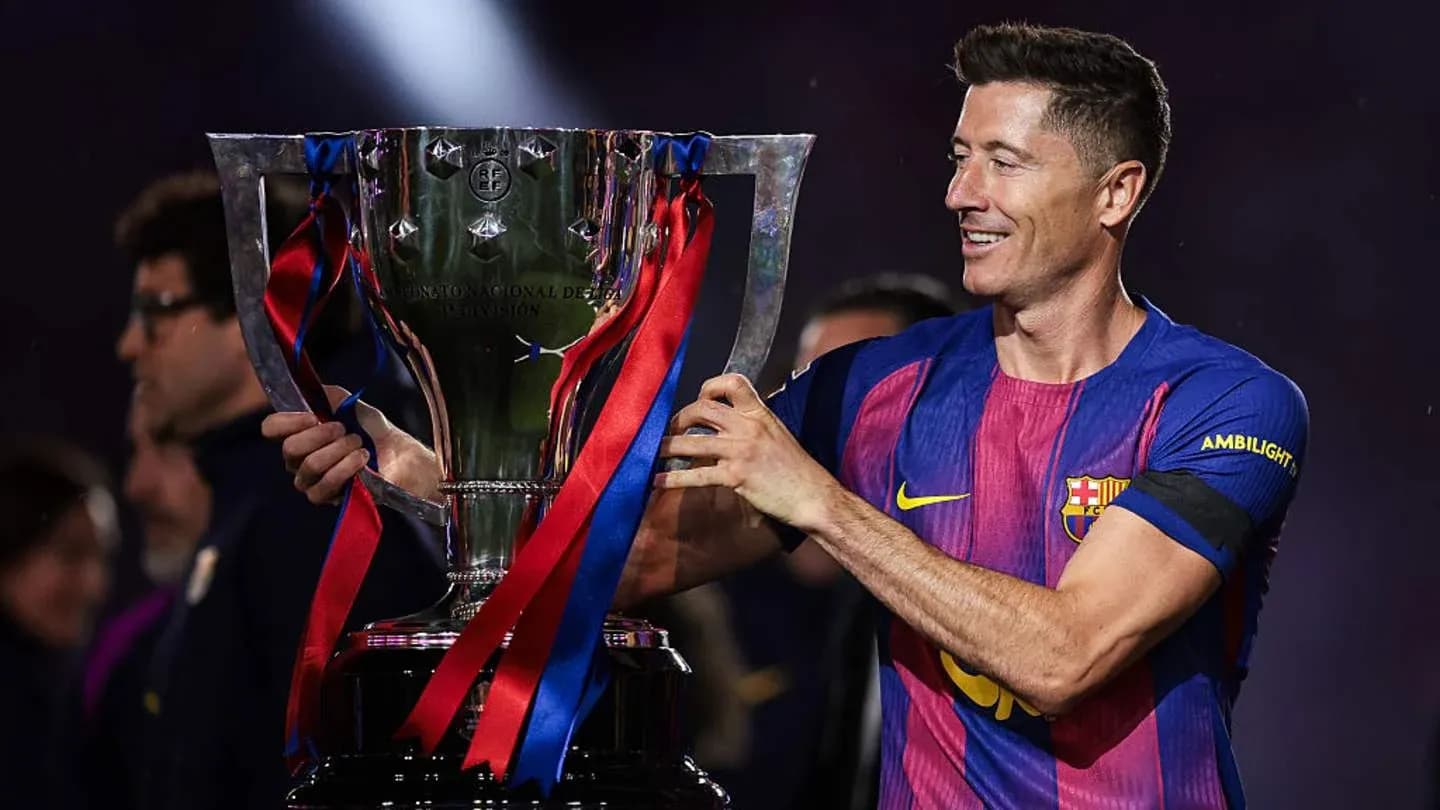 Jugador sosteniendo un trofeo de fútbol en celebración