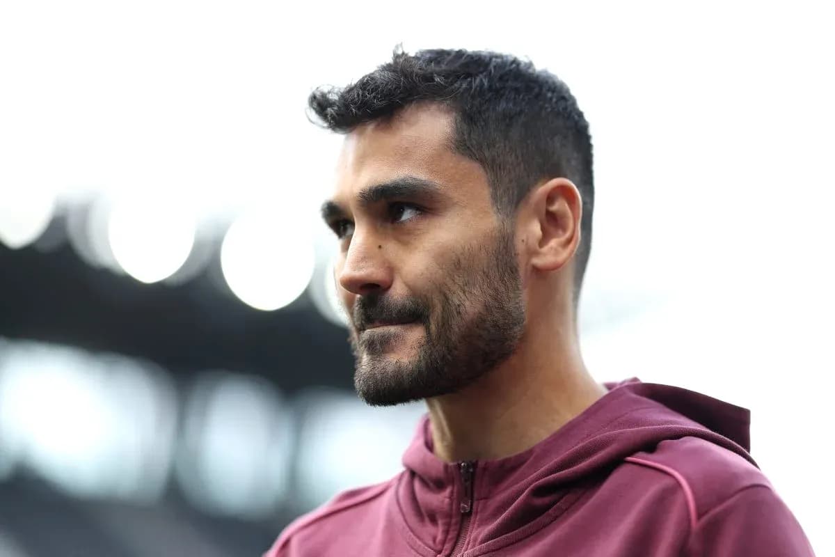 Jugador de fútbol con chaqueta morada en el campo