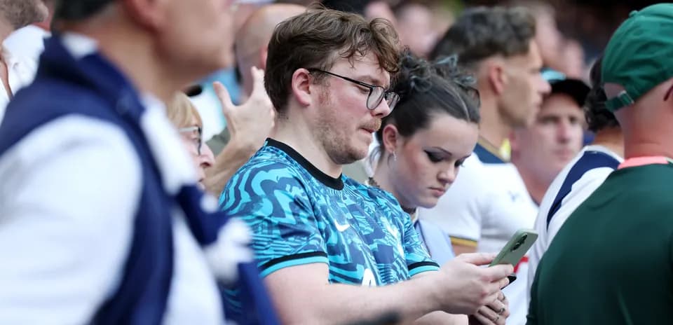 Espectadores en el estadio usando teléfonos móviles