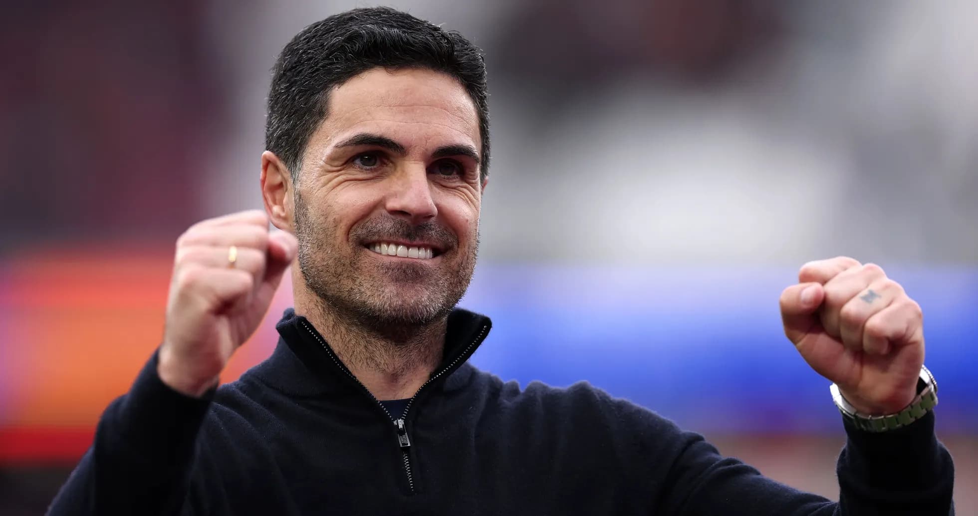 Entrenador sonriendo y levantando puños en celebración