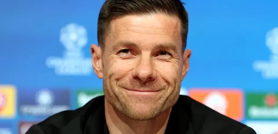 Entrenador sonriendo en rueda de prensa