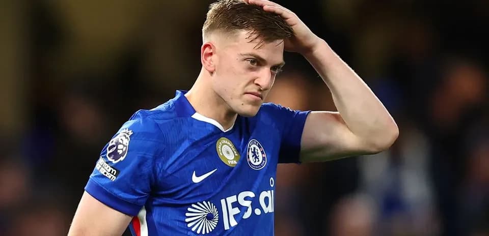 Jugador de Chelsea con camiseta azul tocándose la cabeza
