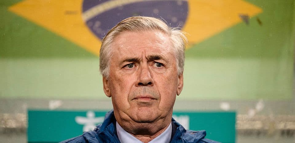 Entrenador de Brasil frente a bandera nacional