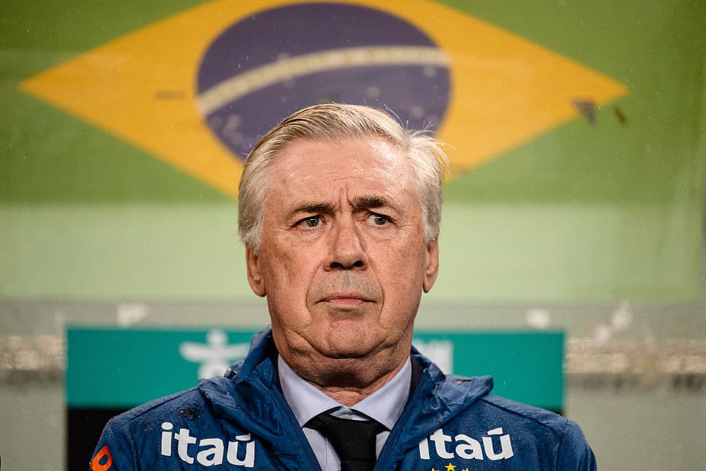 Entrenador de Brasil frente a bandera nacional